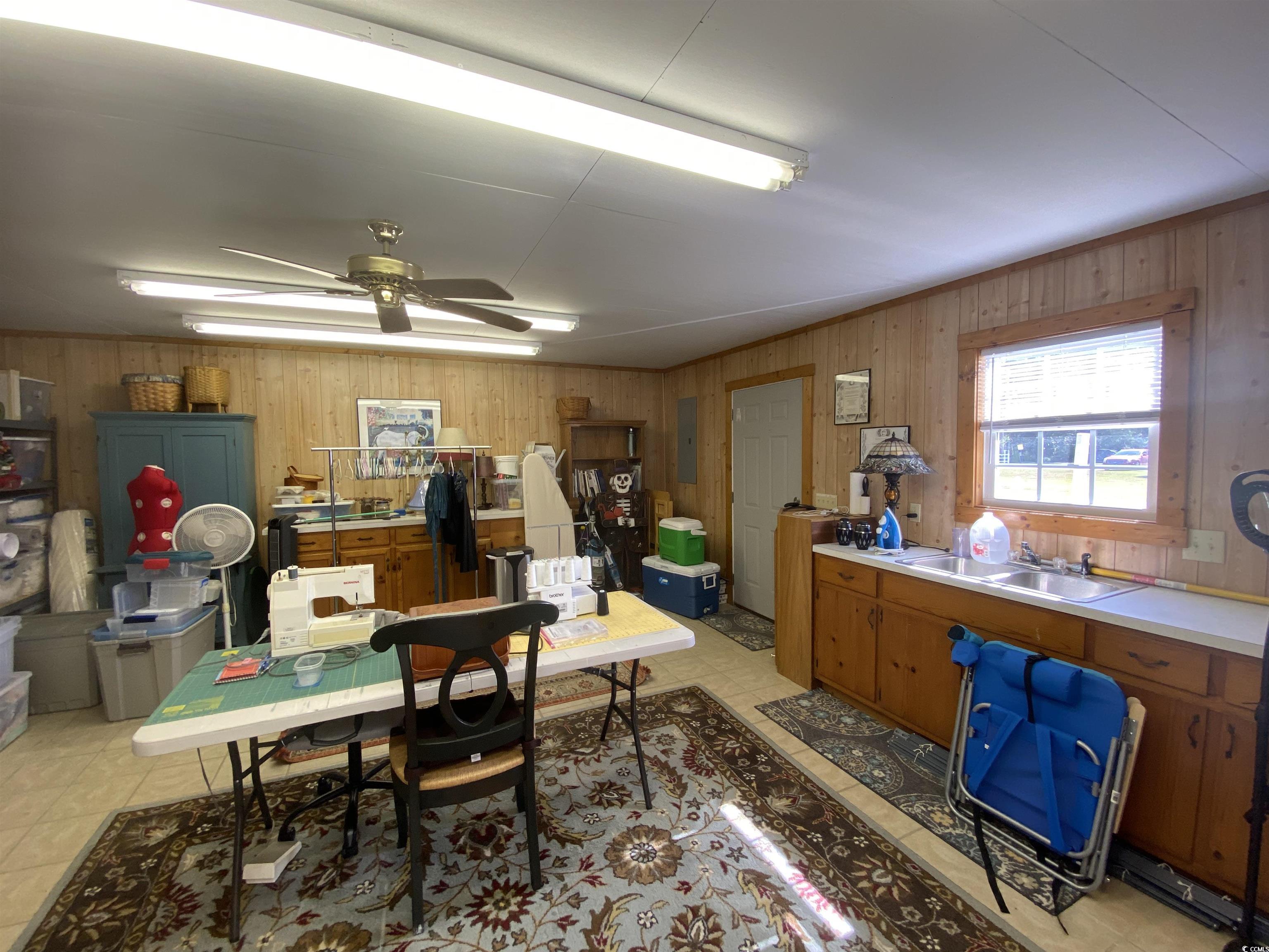 2593 Long Ave Extension Conway, SC 29526 - Photo 10 of 40 Small house with a ceiling fan, wooden walls, light tile patterned floors, and electric panel