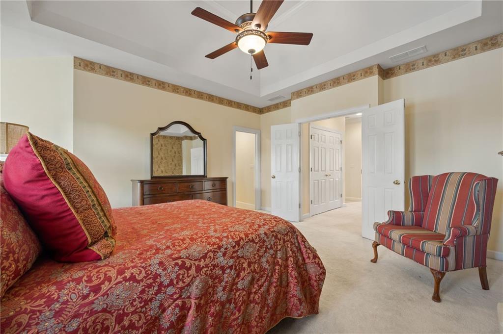 4727 Ivy Ridge Drive Southeast Atlanta, GA 30339 - Photo 13 of 35 a bedroom with a bed couch and a chandelier