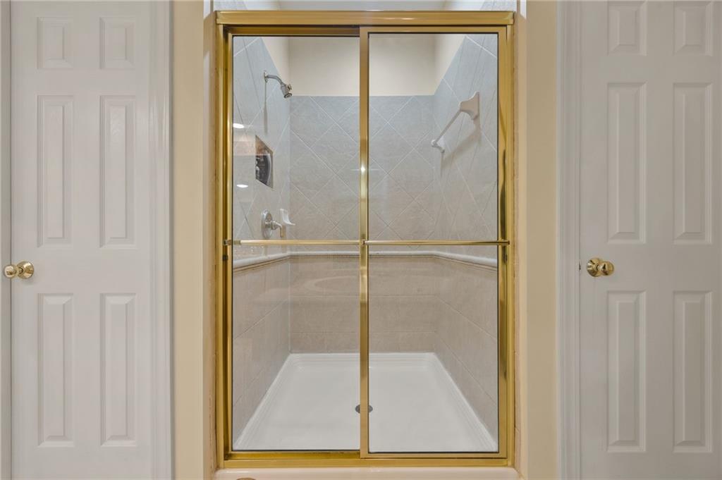 4727 Ivy Ridge Drive Southeast Atlanta, GA 30339 - Photo 16 of 35 a bathroom with a glass shower door