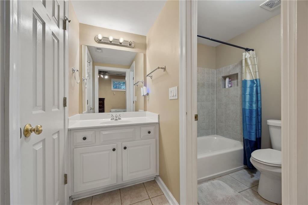 4727 Ivy Ridge Drive Southeast Atlanta, GA 30339 - Photo 30 of 35 a bathroom with a granite countertop sink a toilet and shower