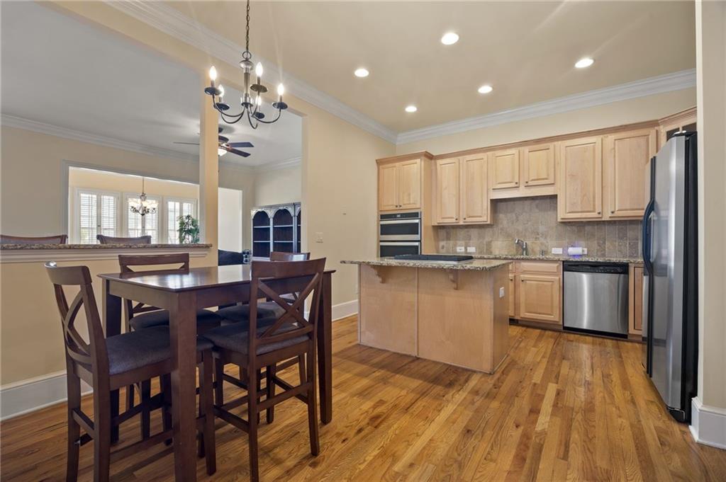4727 Ivy Ridge Drive Southeast Atlanta, GA 30339 - Photo 5 of 35 a kitchen with stainless steel appliances kitchen island granite countertop a wooden table chairs and granite counter tops