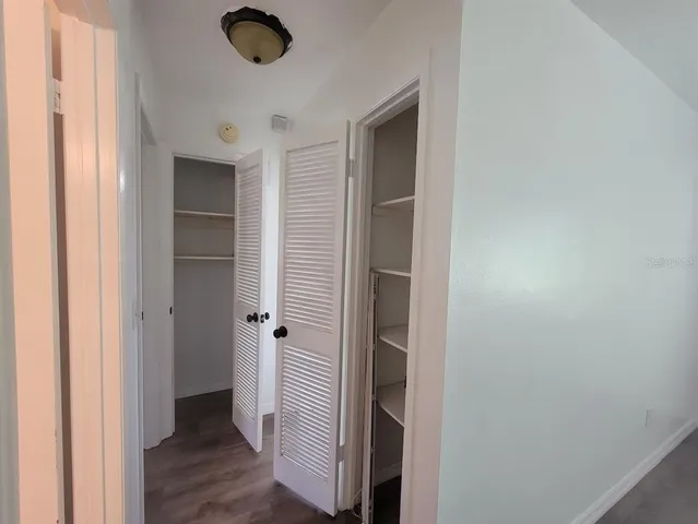 a view of a hallway with wooden floor