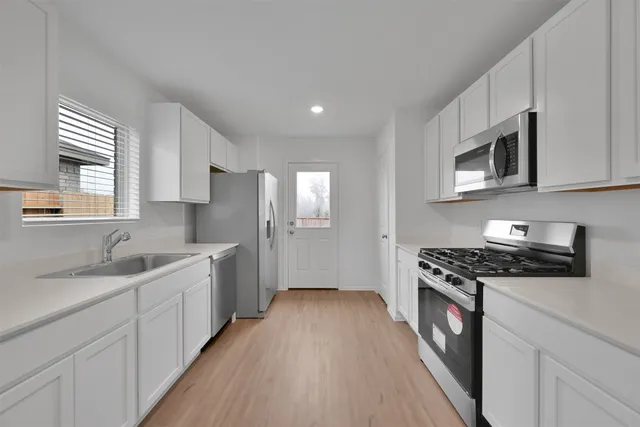 a kitchen with a sink stove top oven and cabinets