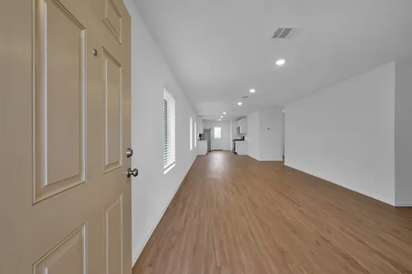 a view of a hallway with wooden floor and staircase