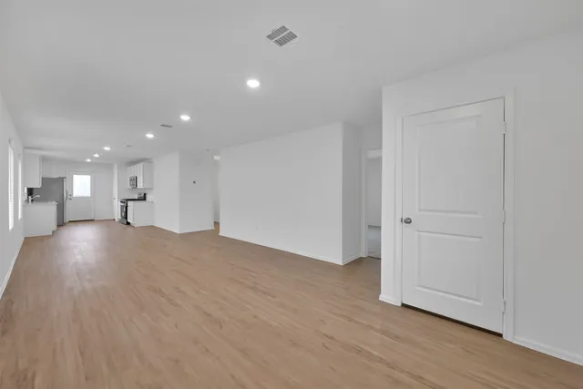 a view of empty room with wooden floor