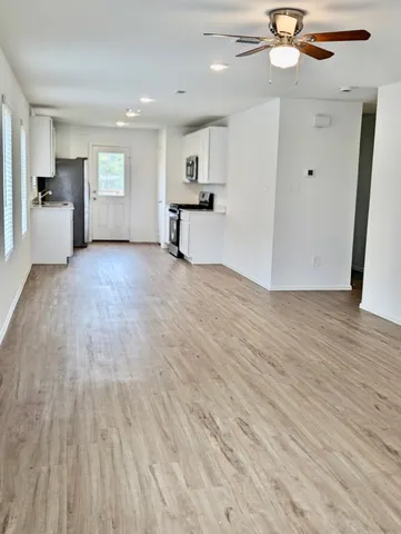 a view of empty room with wooden floor and window