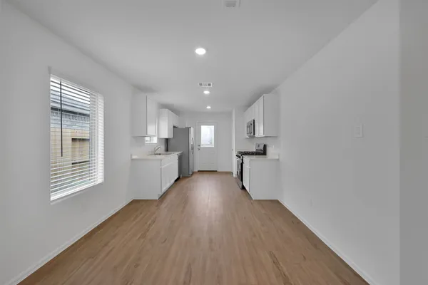 a view of a kitchen with wooden floor and a window