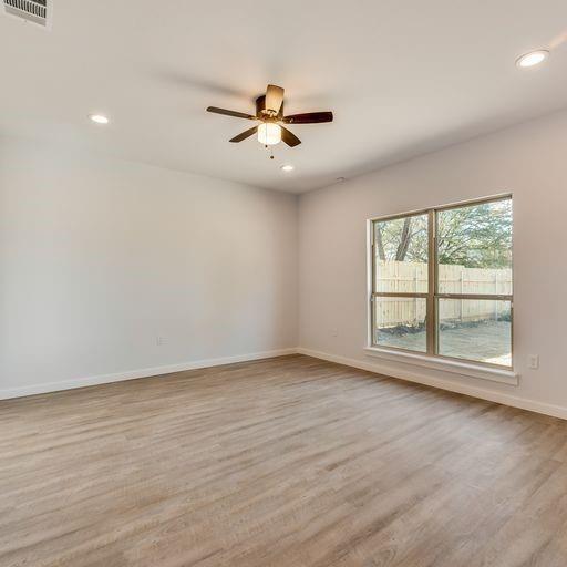 4337 Canal Street Dallas, TX 75210 - Photo 11 of 24 an empty room with wooden floor fan and windows