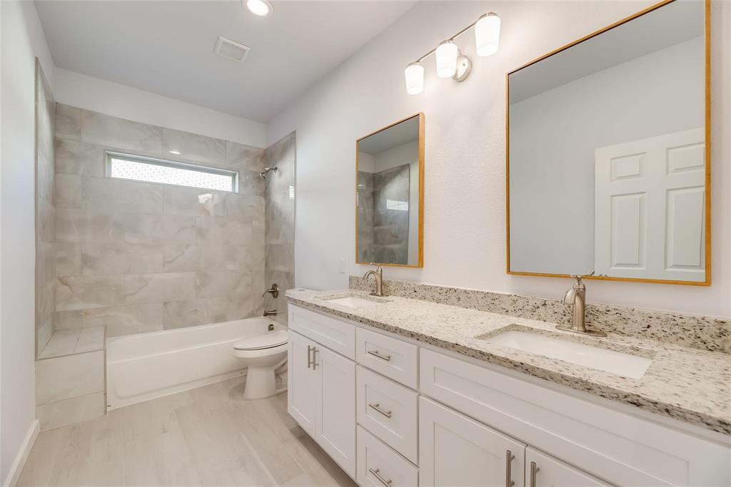 4337 Canal Street Dallas, TX 75210 - Photo 14 of 24 a bathroom with a granite countertop sink a toilet and bathtub
