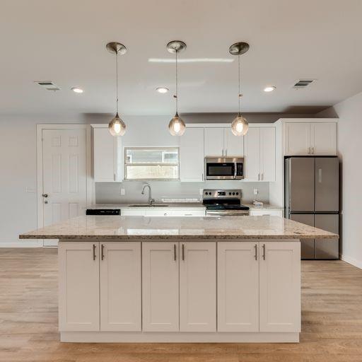 4337 Canal Street Dallas, TX 75210 - Photo 5 of 24 a kitchen with granite countertop a stove a sink and a refrigerator