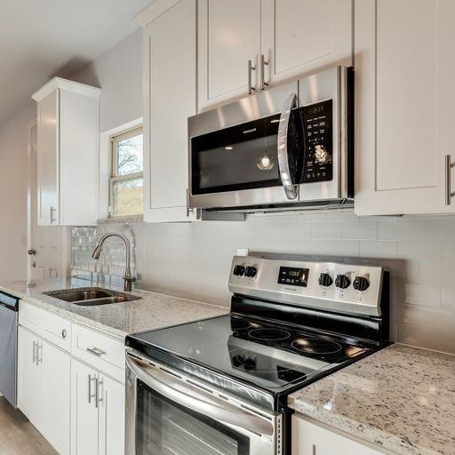 4337 Canal Street Dallas, TX 75210 - Photo 6 of 24 a kitchen with granite countertop a stove and a microwave