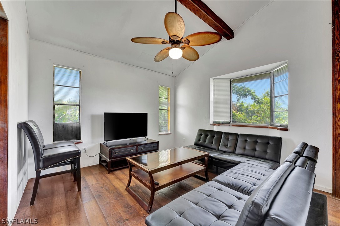 a living room with furniture a ceiling fan and a window