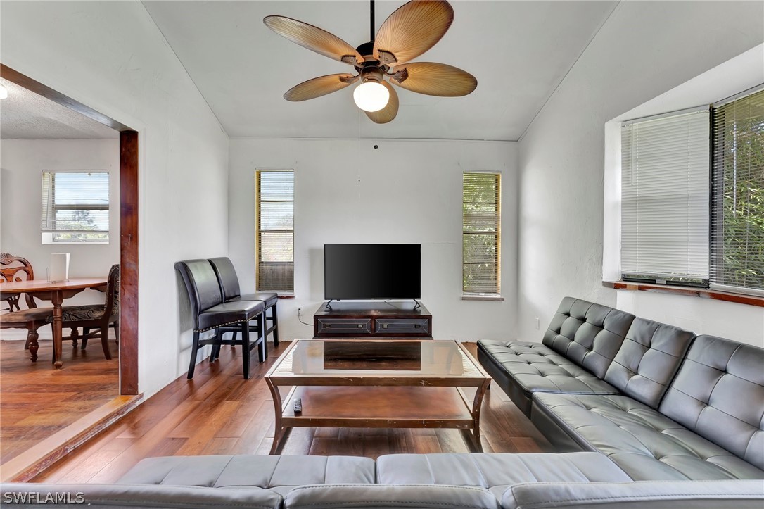 3809 4th Street Southwest Lehigh Acres, FL 33976 - Photo 20 of 34 a living room with furniture and a flat screen tv with wooden floor