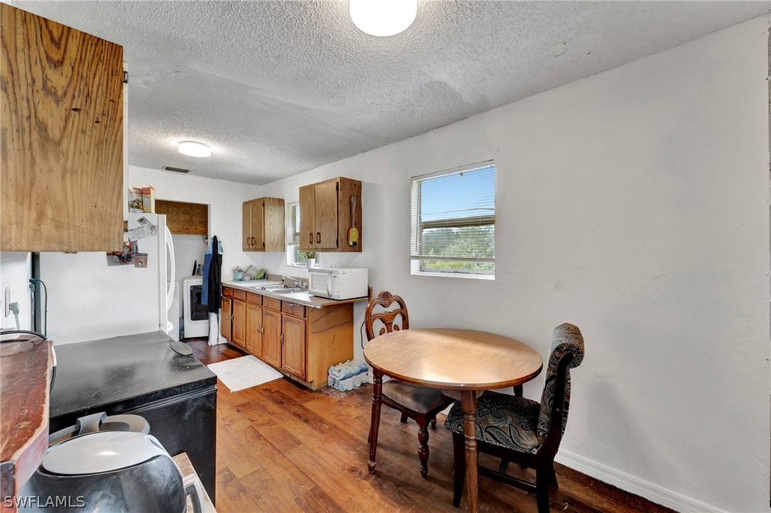 3809 4th Street Southwest Lehigh Acres, FL 33976 - Photo 23 of 34 a kitchen with sink cabinets and dining table