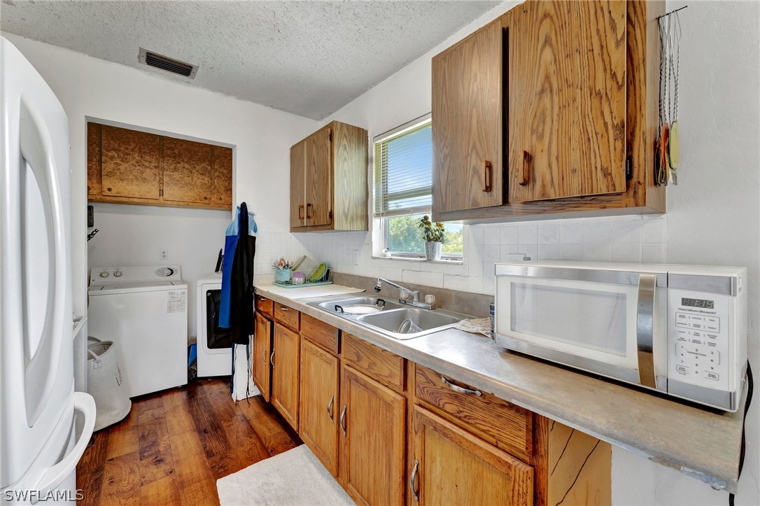 3809 4th Street Southwest Lehigh Acres, FL 33976 - Photo 24 of 34 a kitchen with stainless steel appliances granite countertop a sink stove and refrigerator