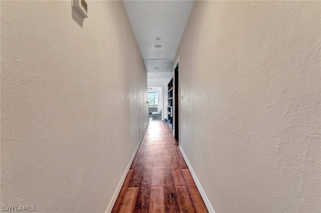 3809 4th Street Southwest Lehigh Acres, FL 33976 - Photo 26 of 34 a view of a hallway with wooden floor and staircase