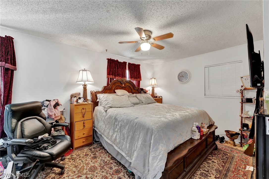 3809 4th Street Southwest Lehigh Acres, FL 33976 - Photo 27 of 34 a bedroom with a bed and a chandelier