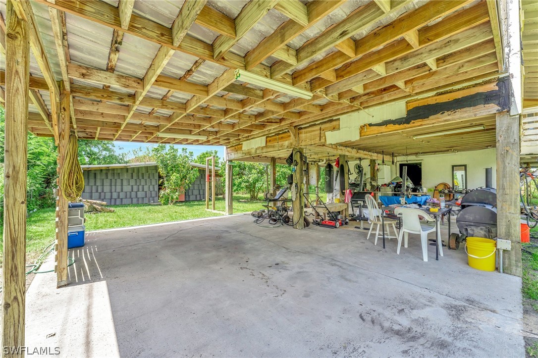 3809 4th Street Southwest Lehigh Acres, FL 33976 - Photo 31 of 34 a view of a patio with table and chairs and potted plants
