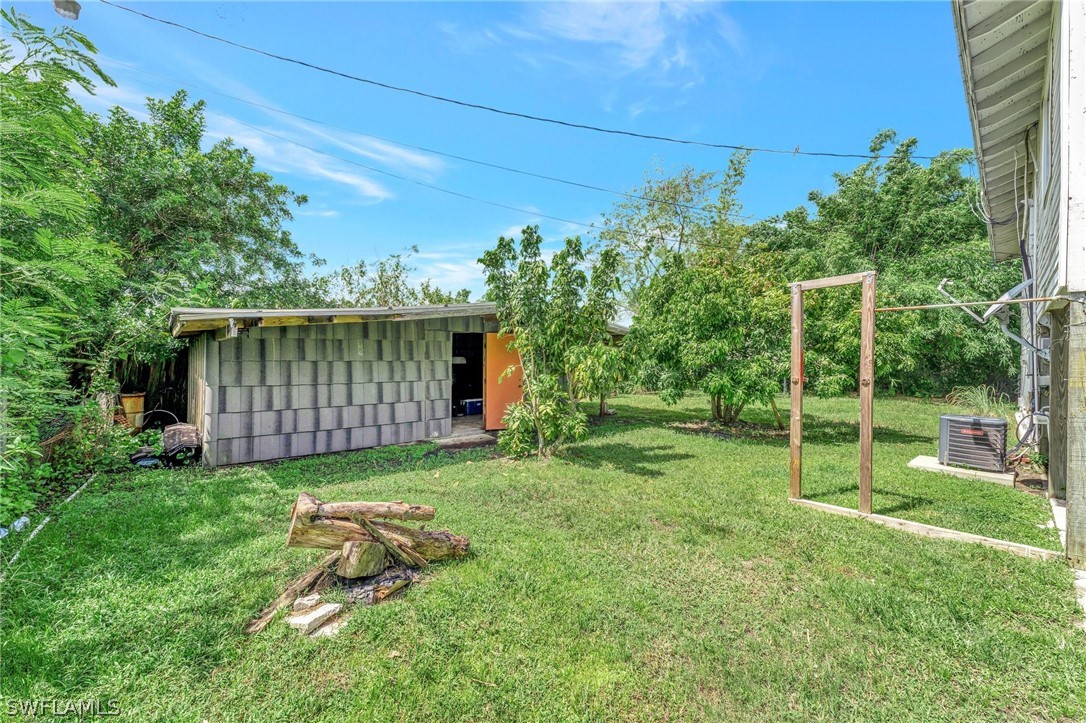 3809 4th Street Southwest Lehigh Acres, FL 33976 - Photo 33 of 34 a view of a backyard with plants and large trees with wooden fence