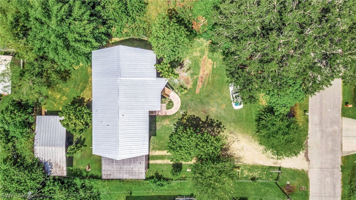3809 4th Street Southwest Lehigh Acres, FL 33976 - Photo 6 of 34 an aerial view of a house with a yard and large trees