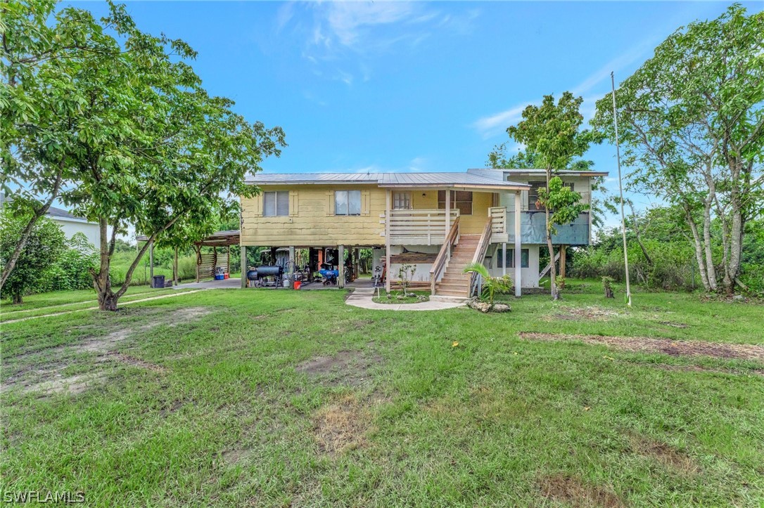 3809 4th Street Southwest Lehigh Acres, FL 33976 - Photo 7 of 34 a view of a house with a big yard and large trees