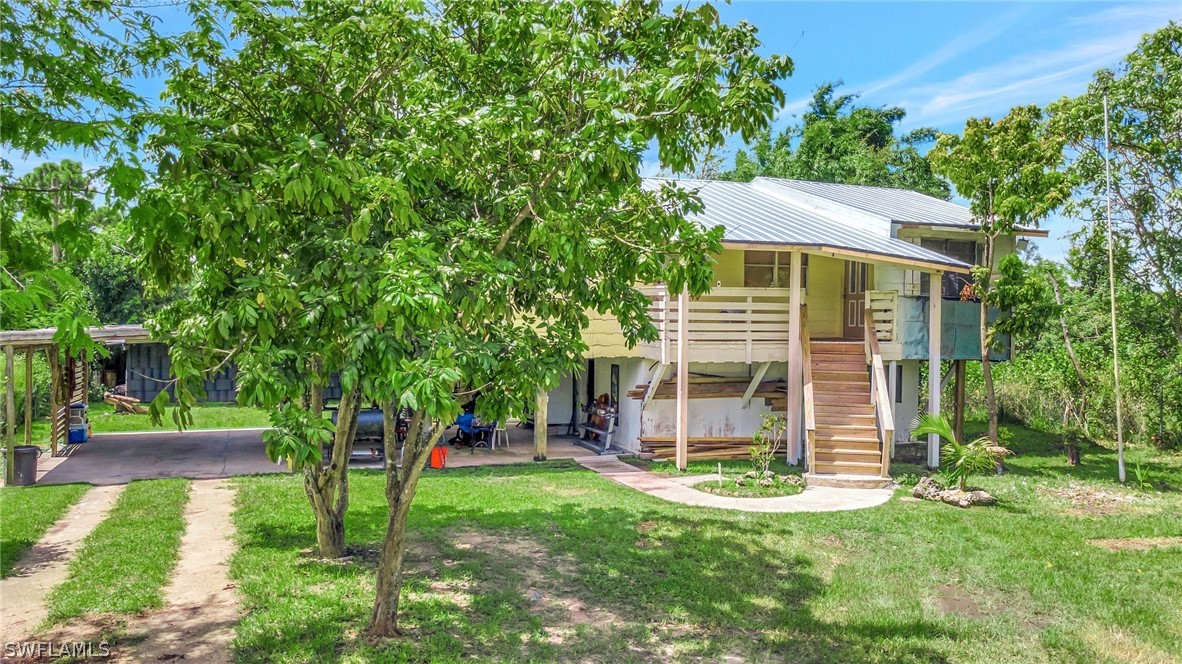 3809 4th Street Southwest Lehigh Acres, FL 33976 - Photo 8 of 34 a view of a house with backyard and a tree