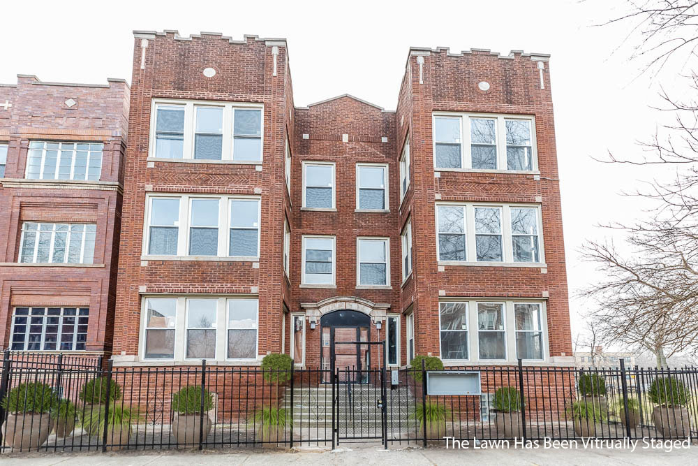 a front view of a large building with iron fence