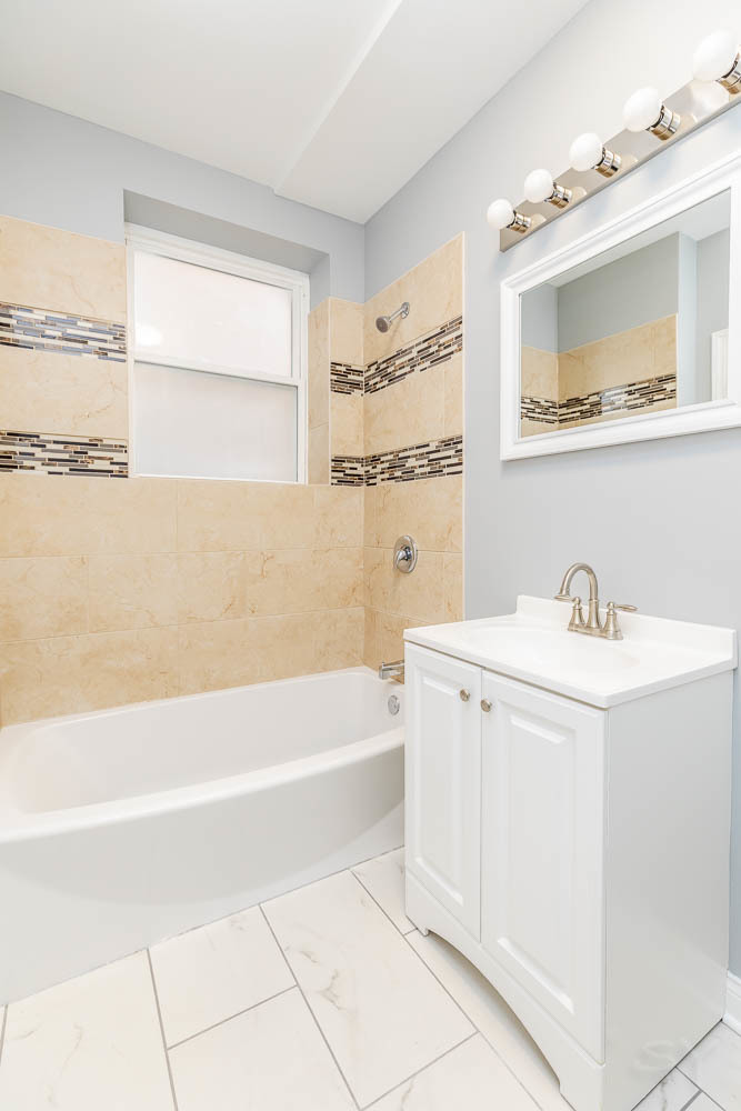 1411 East 67th Place, Unit 2W Chicago, IL 60637 - Photo 7 of 14 a bathroom with a tub sink and mirror