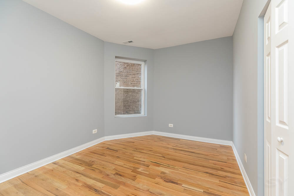1411 East 67th Place, Unit 2W Chicago, IL 60637 - Photo 9 of 14 an empty room with wooden floor and windows