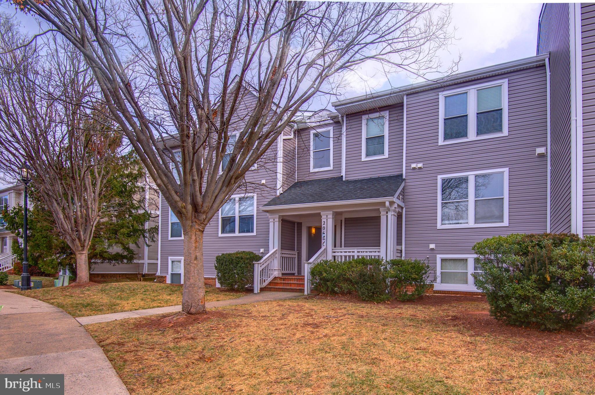 20600 Cornstalk Terrace, Unit 202 Ashburn, VA 20147 - Photo 1 of 31 a front view of a house with garden