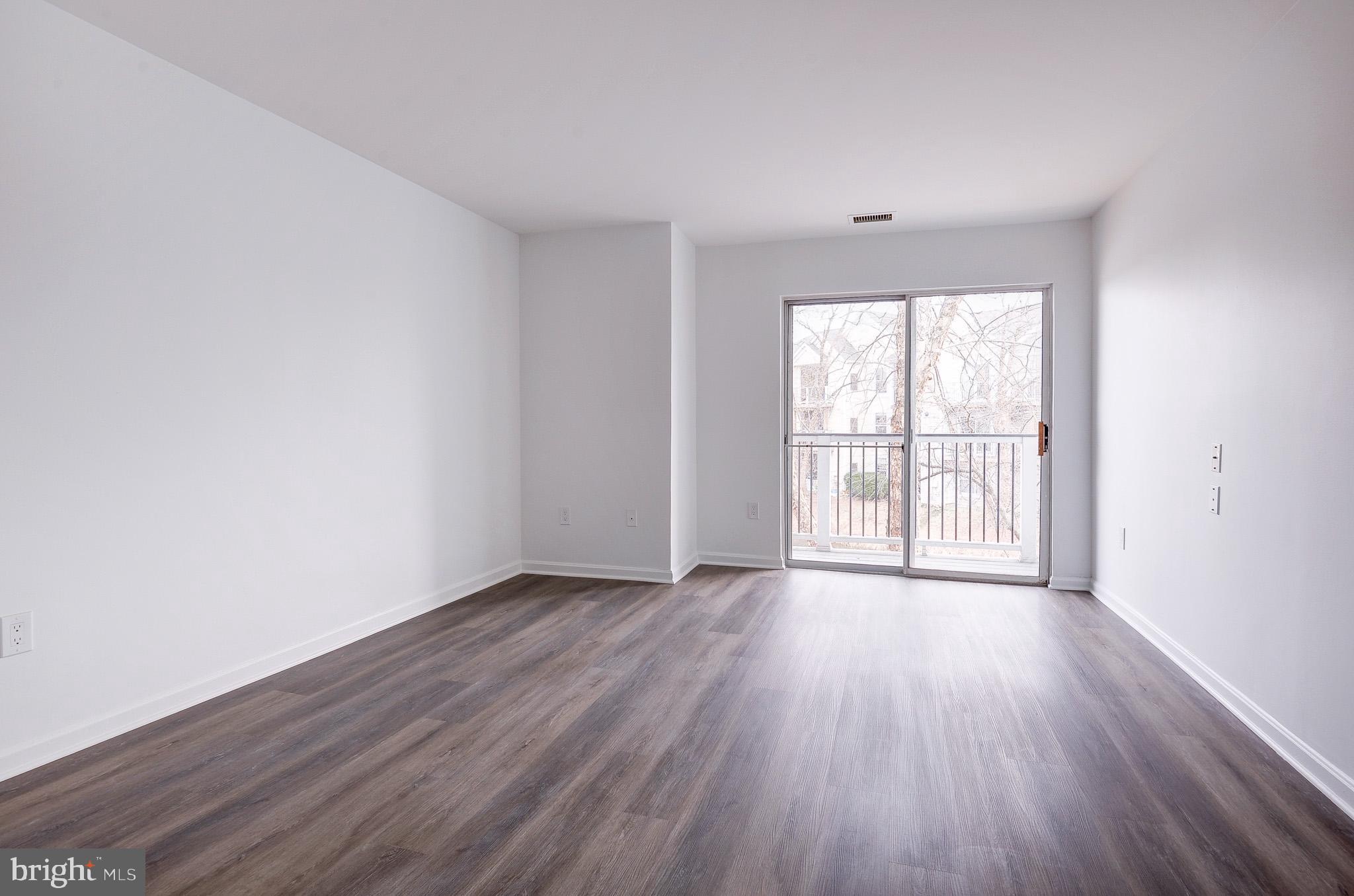 20600 Cornstalk Terrace, Unit 202 Ashburn, VA 20147 - Photo 17 of 31 an empty room with wooden floor and windows