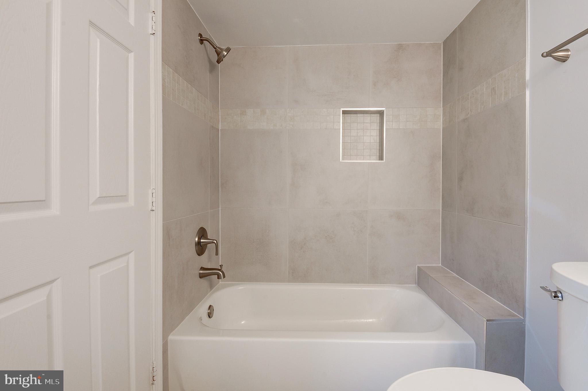 20600 Cornstalk Terrace, Unit 202 Ashburn, VA 20147 - Photo 20 of 31 a white bath tub sitting next to a toilet