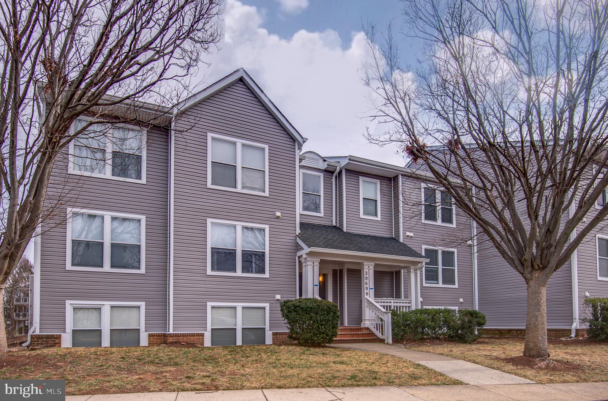 20600 Cornstalk Terrace, Unit 202 Ashburn, VA 20147 - Photo 2 of 31 a front view of a house with yard and trees