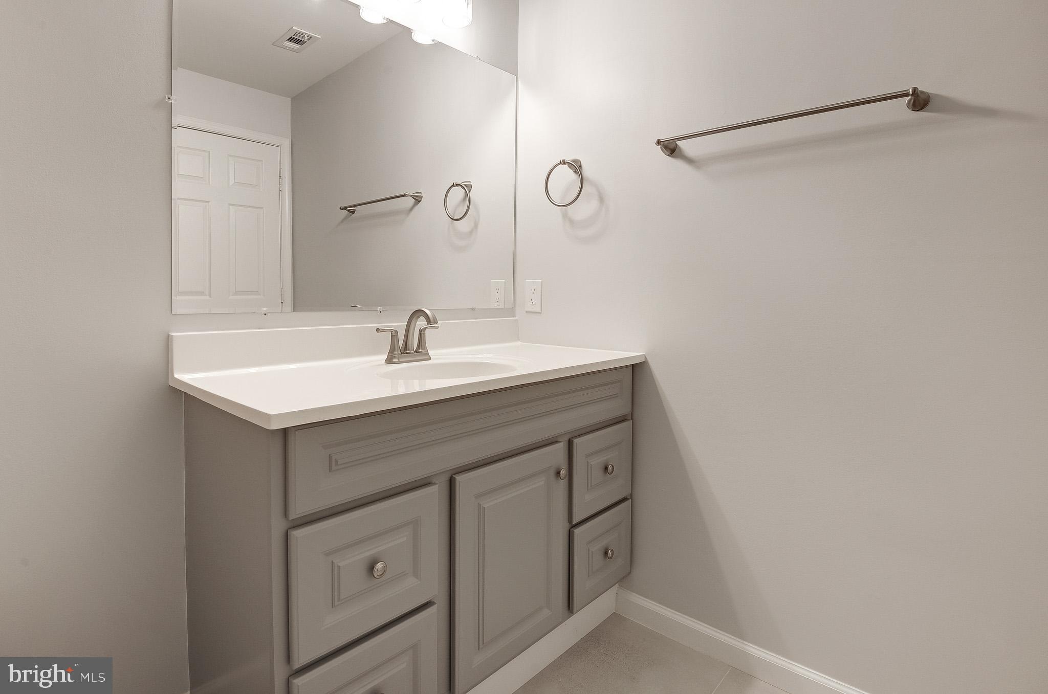 20600 Cornstalk Terrace, Unit 202 Ashburn, VA 20147 - Photo 23 of 31 a bathroom with a sink vanity and a mirror