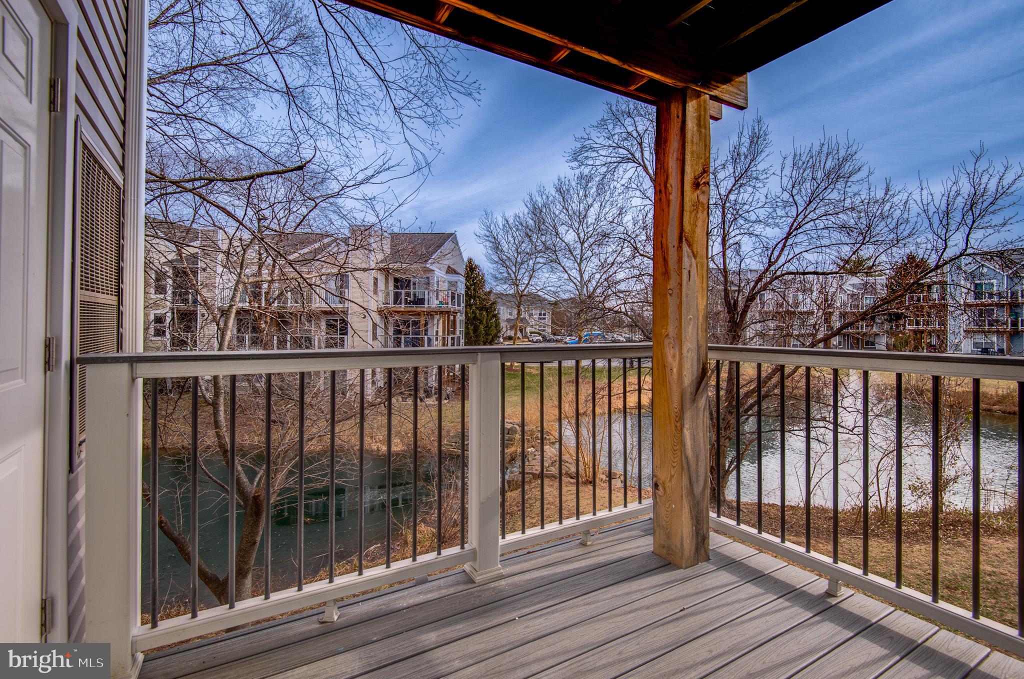 20600 Cornstalk Terrace, Unit 202 Ashburn, VA 20147 - Photo 24 of 31 a view of a balcony with wooden floor and fence