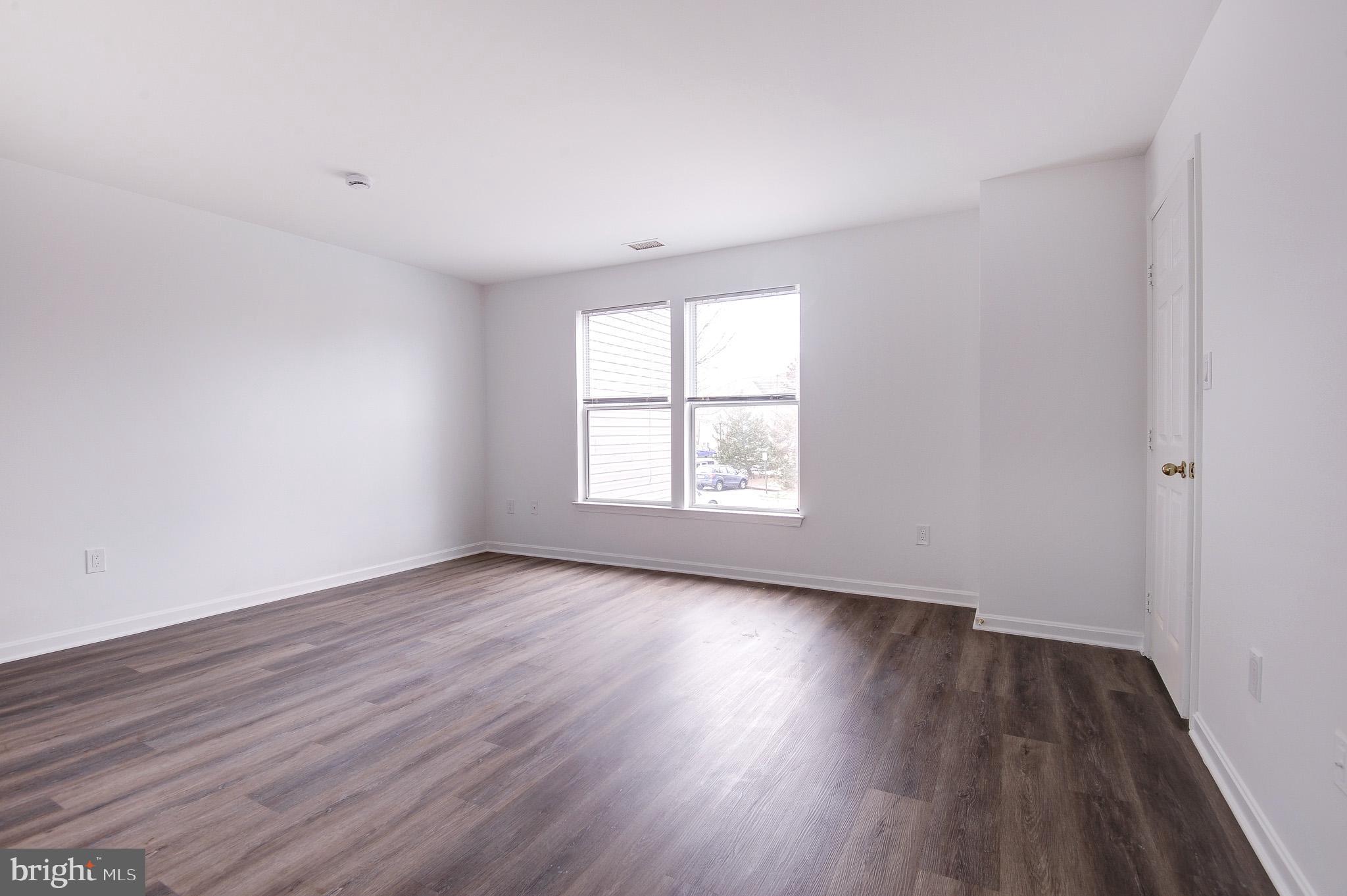 20600 Cornstalk Terrace, Unit 202 Ashburn, VA 20147 - Photo 26 of 31 an empty room with wooden floor and windows