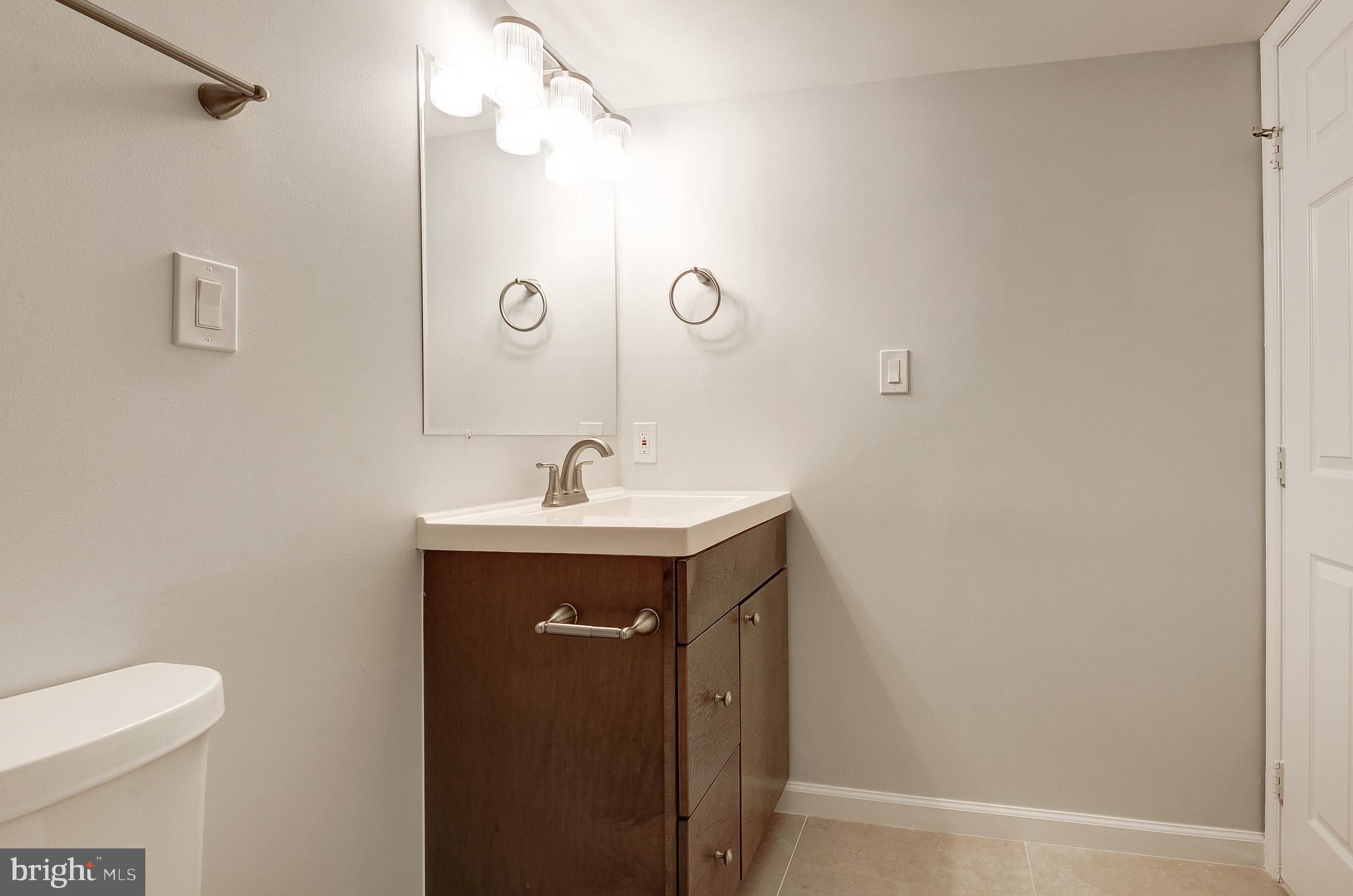 20600 Cornstalk Terrace, Unit 202 Ashburn, VA 20147 - Photo 29 of 31 a bathroom with a sink a toilet and shower