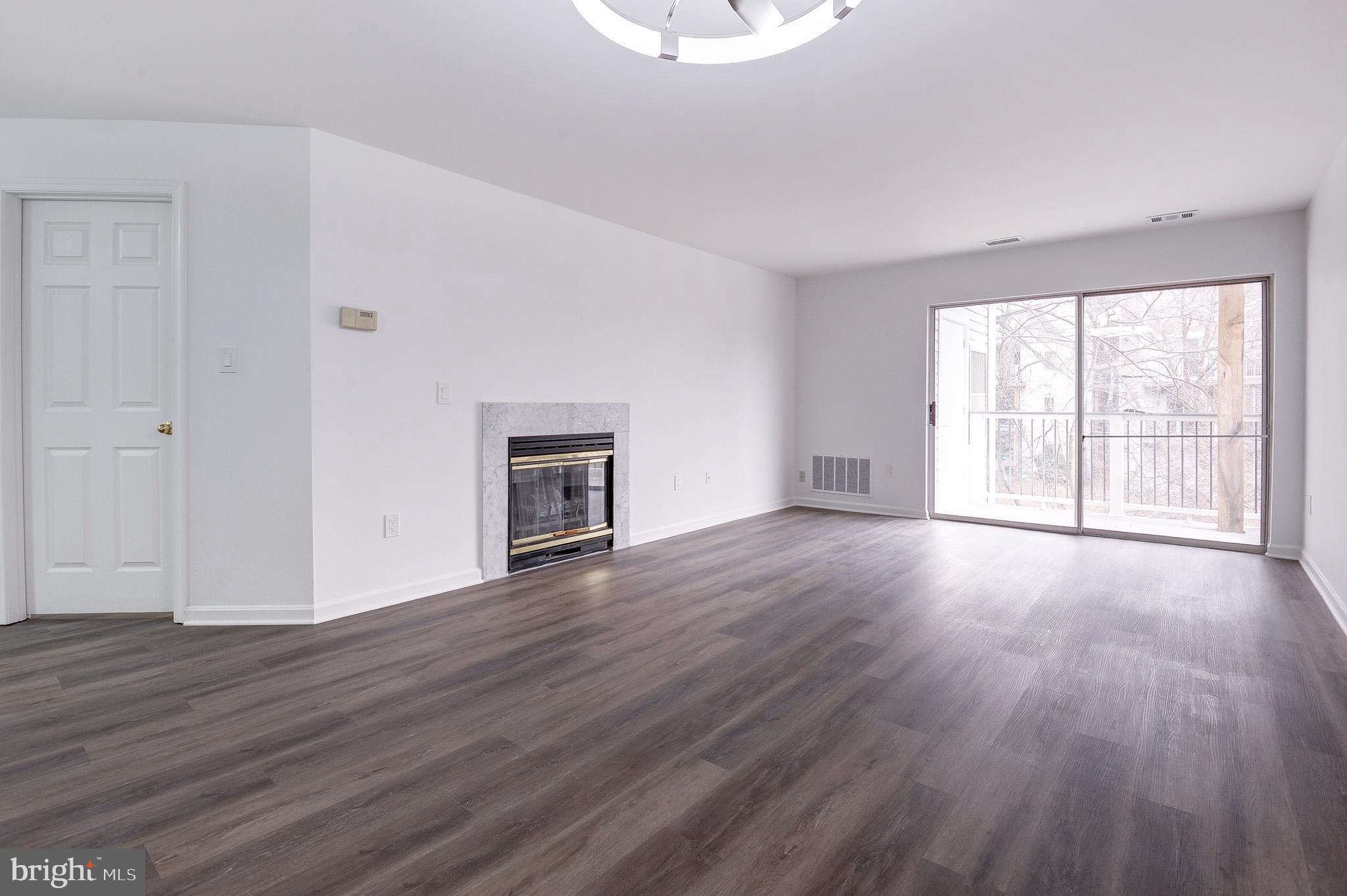 20600 Cornstalk Terrace, Unit 202 Ashburn, VA 20147 - Photo 4 of 31 an empty room with wooden floor and windows