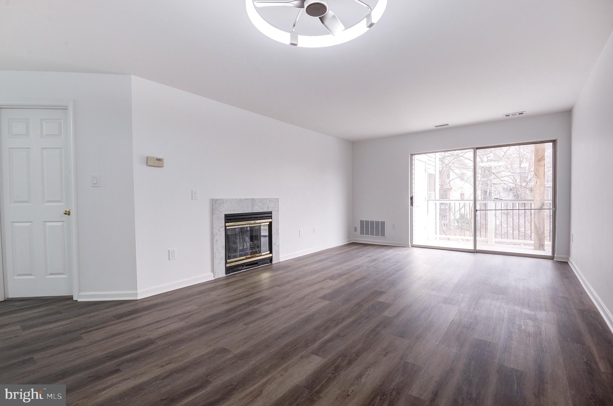 20600 Cornstalk Terrace, Unit 202 Ashburn, VA 20147 - Photo 5 of 31 a view of an empty room with wooden floor and a window