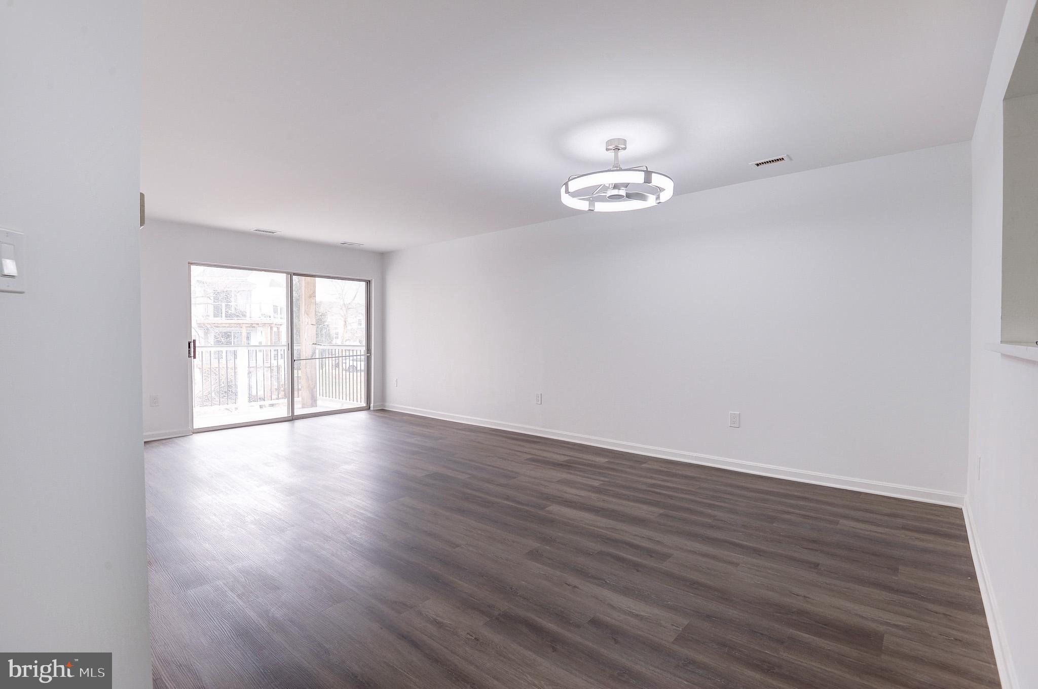 20600 Cornstalk Terrace, Unit 202 Ashburn, VA 20147 - Photo 9 of 31 a view of empty room with wooden floor and fan