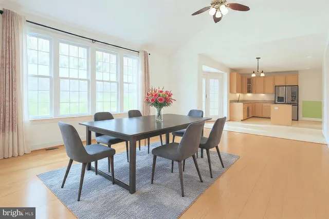 a view of an empty room with window and a kitchen view