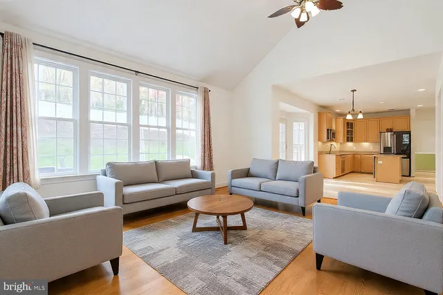 a view of an empty room with wooden floor fireplace and a window