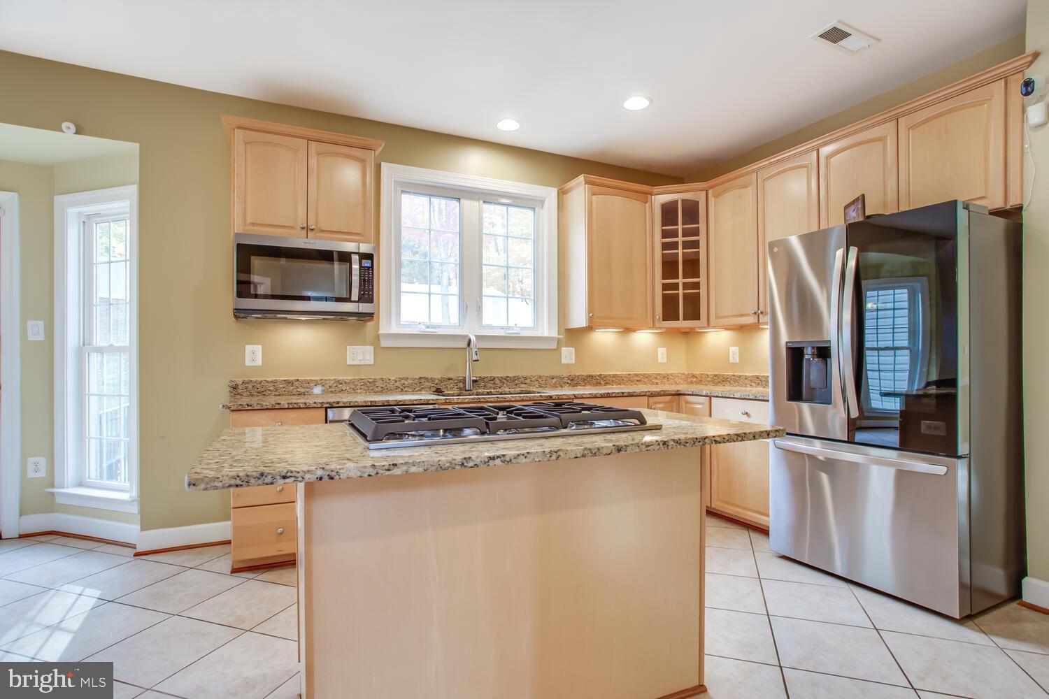 3403 Logstone Drive Triangle, VA 22172 - Photo 20 of 66 a kitchen with granite countertop a refrigerator and a stove top oven