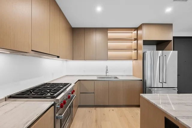 a kitchen with granite countertop a sink a stove and cabinets