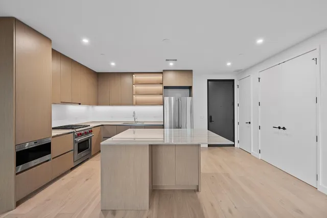 a kitchen with stainless steel appliances granite countertop a sink a stove and a refrigerator