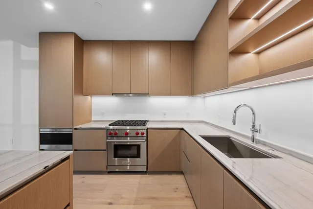 a kitchen with stainless steel appliances granite countertop a sink and a stove