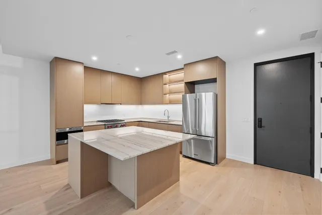 a kitchen with stainless steel appliances granite countertop a refrigerator and a sink