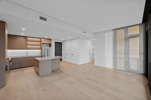 a view of kitchen with kitchen island white cabinets and refrigerator