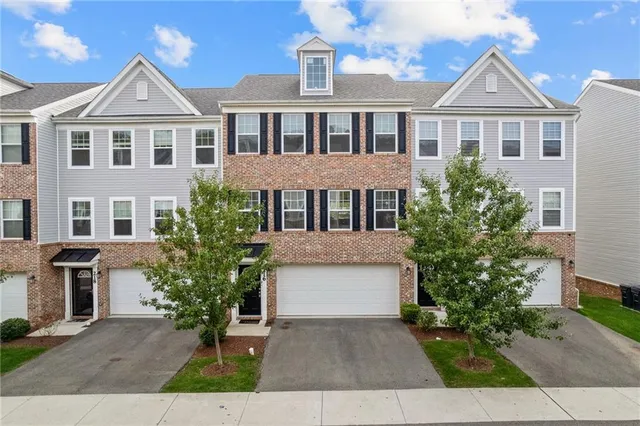 a front view of a house with a yard and trees