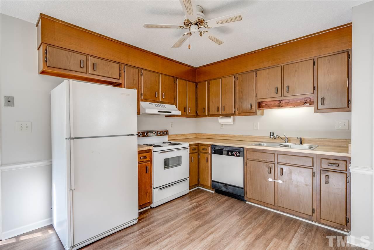 7408 Mine Shaft Road Raleigh, NC 27615 - Photo 15 of 20 a kitchen with stainless steel appliances granite countertop a refrigerator a stove a sink and white cabinets